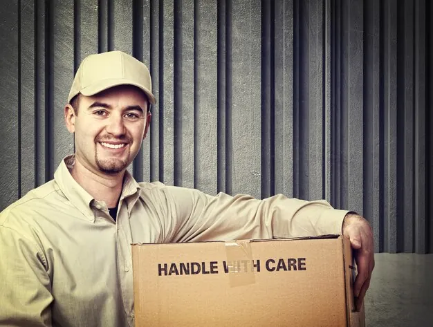 Smiling courier holding a Handle With Care parcel